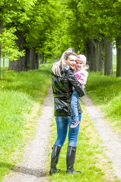 Mother with her little daughter in spring alley — Stock Photo, Image