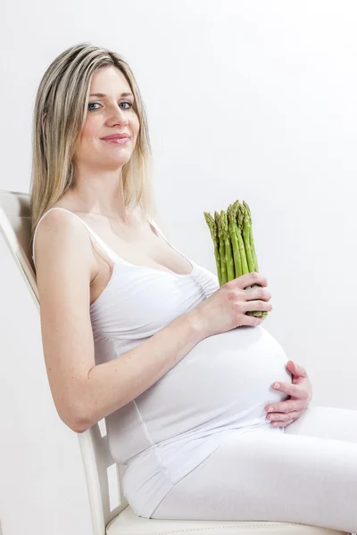 Retrato de mujer embarazada sosteniendo espárragos verdes —  Fotos de Stock