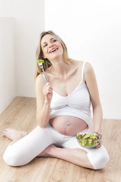 Těhotná žena jíst zeleninový salát — Stock fotografie