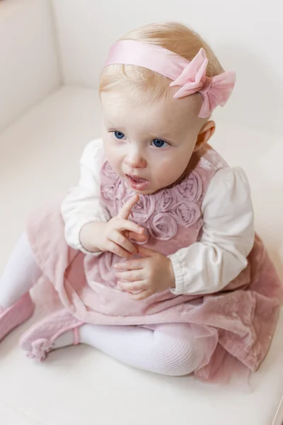 Portréja ül a kisgyermek lány visel rózsaszín ruha — Stock Fotó