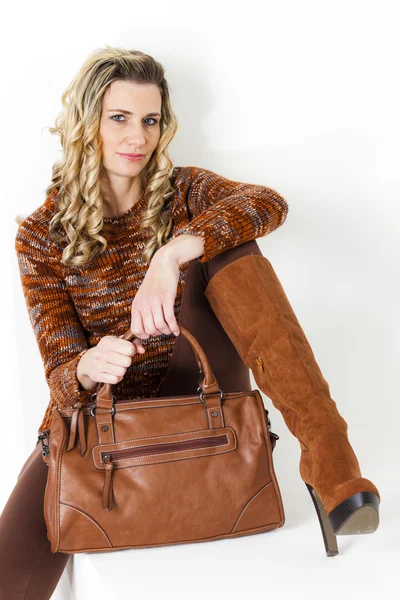Portret van zittende vrouw dragen bruine kleding en laarzen met een — Stockfoto