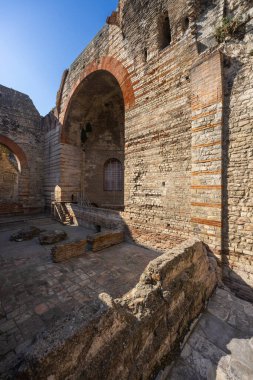 Antik Roma duvarları ve kemerleri açık mavi gökyüzünün altında tarihi mimariyi gösteriyor.