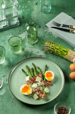 Yumuşak yumurta, kıtır pastırma ve taze kuşkonmaz mızraklı sağlıklı bir kahvaltı.