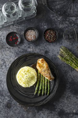 Kızarmış tavuk göğsü, patates püresi ve yeşil kuşkonmaz sağlıklı bir gurme yemeği yaratır.