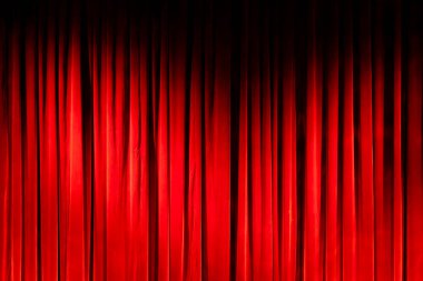 Koyu kırmızı kadife perde sahne arkaplanı oluşturuyor