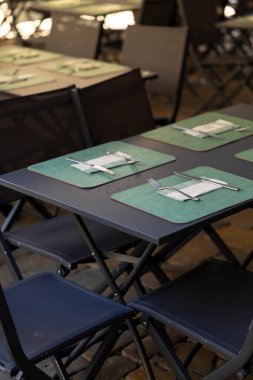 Boş bistro masaları, dışarıda yemek için hazır sandalyeler, müşteriler için hazır.