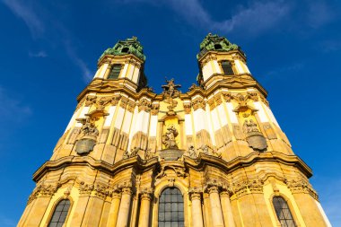 Polonya, Krzeszow 'daki Barok Manastırı Bazilikası mavi gökyüzüne karşı iki süslü kuleyi gösteriyor.