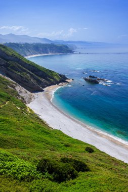 Yeşil uçurumların dibinde turkuaz suyu olan tenha Playa del Silencio plajı.