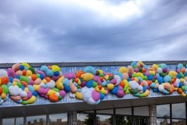 Çoklu renkli şekillerin yer aldığı hareketli soyut sanat, eğlenceli bir cephe dekorasyonu oluşturur.