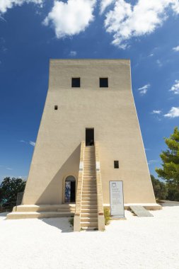 İtalya, Vieste 'de canlı mavi gökyüzüne karşı harici merdiveni olan modernist kule yapısı