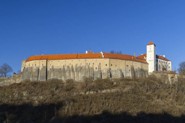 Bitov Kalesi, açık mavi gökyüzünün altında tarihi bir bina ve turuncu bir çatı barındırıyor.