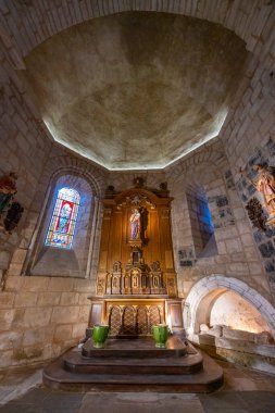 Kilisenin içinde sunak, heykel, vitray ve taş lahit var.