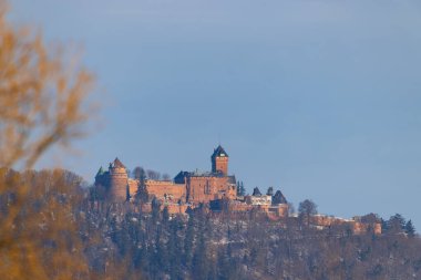 Haut Koenigsbourg Şatosu, Bas Rhin, Fransa 'da ağaçlar ve açık gökyüzü ile tarihi bir simgedir.