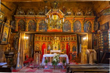 Polonya 'daki tarihi ahşap bir kilisede büyük bir ikonostaz ve sunak.