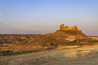 Montearagon Kalesi, akşam ışığında parlayan bir tepenin üzerinde duran harabeler.