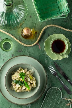 Brokoli ve parmesanlı risotto, kahve ile birlikte yeşil bir masada hazır.