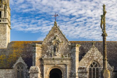 Brittany, Fransa 'da bulutlu mavi gökyüzü altında tarihi taş kilise ve süvariler anıtı