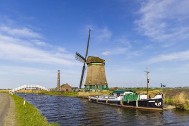 Hollanda 'nın tarihi yel değirmeni, Nieuweweg, Kuzey Hollanda' da bir kanalın yanında duruyor.