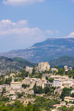 Montbrun les Bains köyü. Evleri, kilisesi, şatosu ve dağları olan bir tepede.