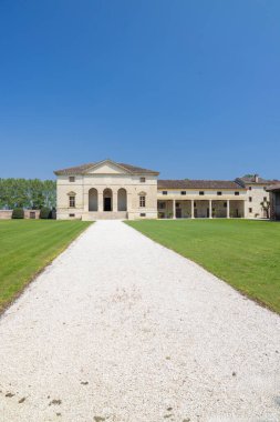 Villa Saraceno, klasik mimarisi olan bir bina, açık mavi gökyüzünün altında duruyor.