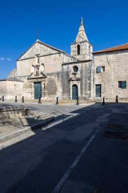 Parlak mavi gökyüzünün altında çan kulesi olan tarihi kilise yapısı.