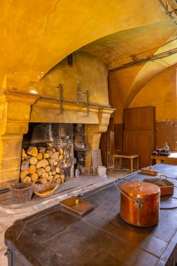 Geleneksel bakır tencerelerin yer aldığı büyük şömineli ve eski pişirme fırınlı tarihi mutfak.