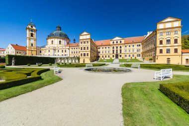 Barok şatosu ve kilise titizlikle bakılan mavi gökyüzü altındaki Fransız bahçesine hakim.