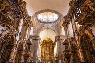 Süslü barok kilisenin içinde yaldızlı sunak, kemer ve karmaşık dini sanat eserleri var.