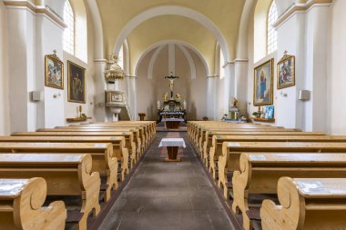 Kilisenin içinde ahşap sıralar, haçlı bir sunak ve kürsü var.