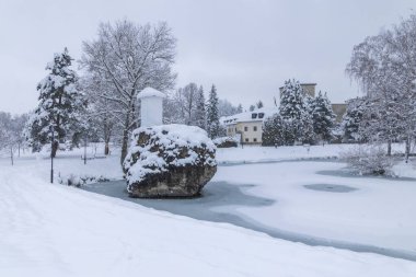 Kar, tarihi bir şato, donmuş bir gölet ve kış parkındaki ağaçlarla kaplıydı.
