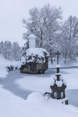 Kış harikalar diyarı. Karla kaplı bir kaya ve Slovakya 'da donmuş bir gölet.