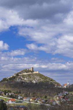 Staatz Kalesi yıkıntısı, kayalık bir tepenin üzerinde duruyor. Önünde bir Avusturya köyü var.