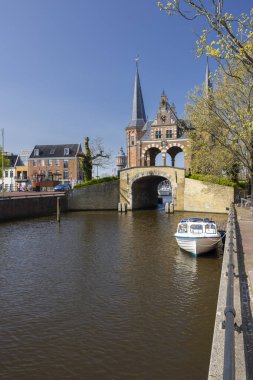 Sneek 'teki tarihi Waterpoort kapısı kanalın üzerinde demirli küçük bir tekneyle duruyor.