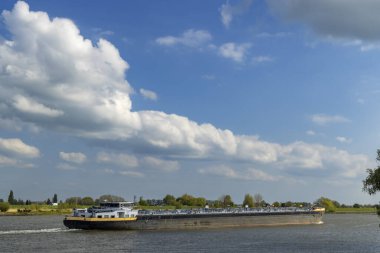 Lekdijk West, Hollanda 'da mavi gökyüzü altında ilerleyen bir tanker gemisi.