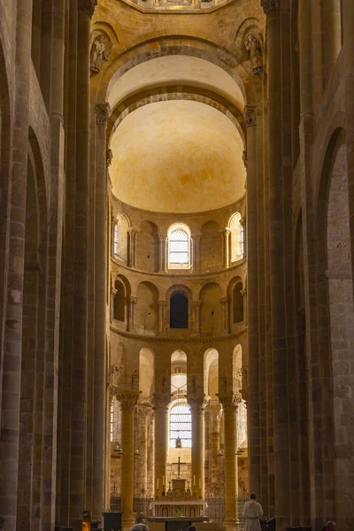 Manastır kilisesinin iç kısmı sunağın etrafında antik Romanca mimari, kemer ve sıcak ışığı gösteriyor.