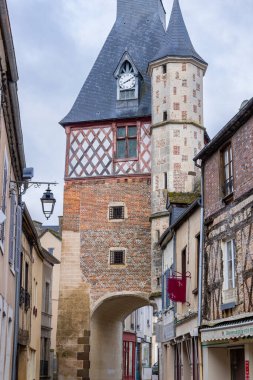 Saint Fargeau, Fransa 'da büyüleyici bir caddenin üzerinde saat ve kemer bulunan tarihi kule.