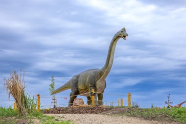 Brachiosaurus dinozor heykeli Chvalovice dinozor parkında bulutlu bir gökyüzünün altında duruyor.