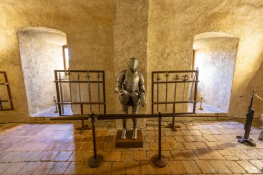 Zırh ve ortaçağ silahları tarihi bir kale odasında sergileniyor.