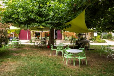 Saint Jean de Cole 'da büyük bir ağacın altında açık restoran terası.