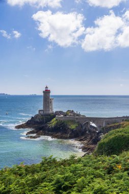 Atlantik Okyanusu ve mavi gökyüzü ile kayalık sahildeki tarihi deniz feneri ve köprü