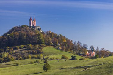 Manzaralı bir tepenin üzerindeki barok süvariler mavi gökyüzünün altında sonbahar renklerini yakalıyorlar.