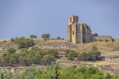 Kuru bir tepede duran eski taş kilise kalıntıları berrak bir yaz gökyüzünün altında.