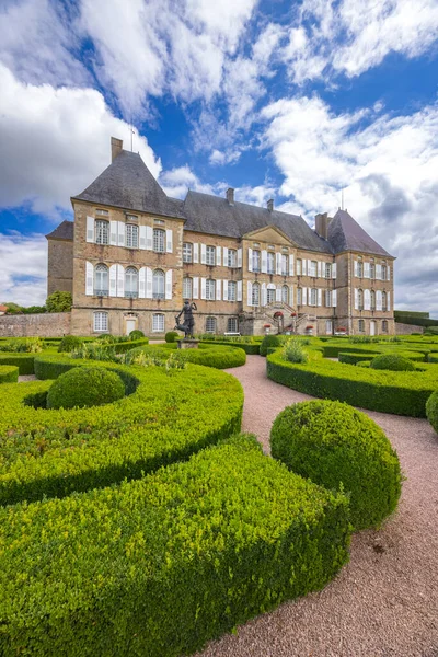 Curbigny Şatosu büyük mimari sergiliyor ve titizlikle budanmış ağaç bahçesi.