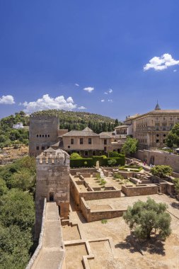 Alhambra kompleksi Granada, İspanya 'da açık bir gökyüzünün altında antik duvarları, binaları ve bahçeleri gösteriyor.