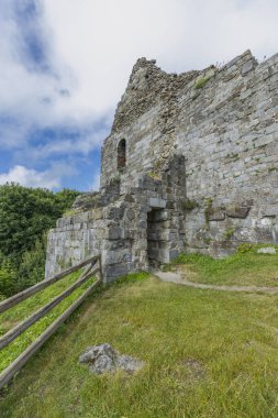 Çekoslovakya, Primda 'da çimenli bir yamaçta girişi ve ahşap çiti olan antik taş kale harabeleri.