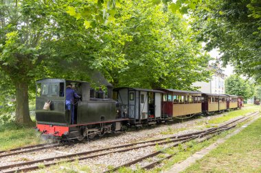 Fransa kırsalında güneşli bir günde yolcu taşıyan klasik buhar treni.
