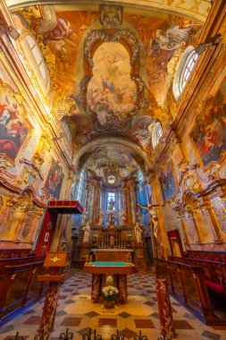 Süslü barok kilise iç mimarisi ayrıntılı freskler, yaldızlı sıva ve geleneksel dini sanat eserleri sergileniyor.