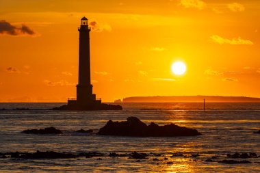 Fransa 'nın La Hague kentindeki altın bir akşamda Kanal sularından yükselen Gatteville Feneri