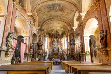 Kilisenin içini ahşap sıralarla süslemek büyük bir sunak ve dekoratif tavana götürür.