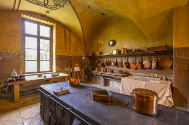 Geleneksel fırın ve klasik bakır kaplar içeren tarihi Fransız şatosu mutfağı.